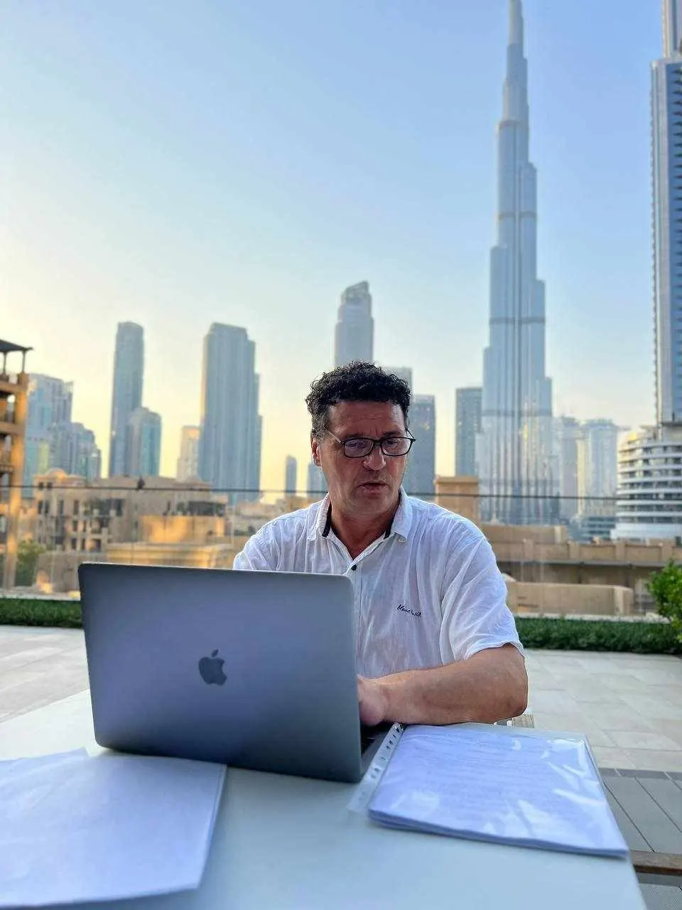 Denis Kleva working on a laptop on a sunny terrace